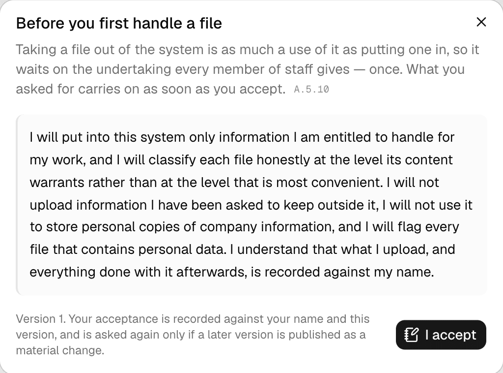 A dialog headed Before you first handle a file: Taking a file out of the system is as much a use of it as putting one in, so it waits on the undertaking every member of staff gives — once. The undertaking's wording, Version 1, and an I accept button.